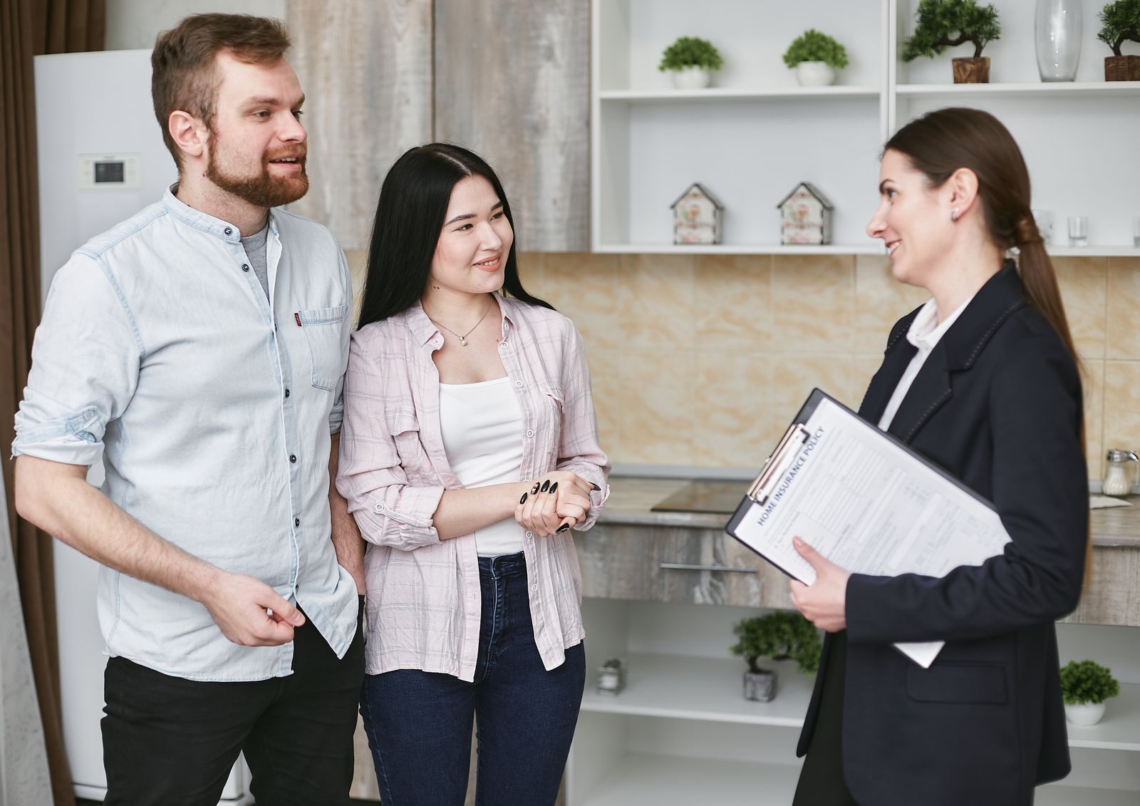 An agent talking with a young couple in a bright room